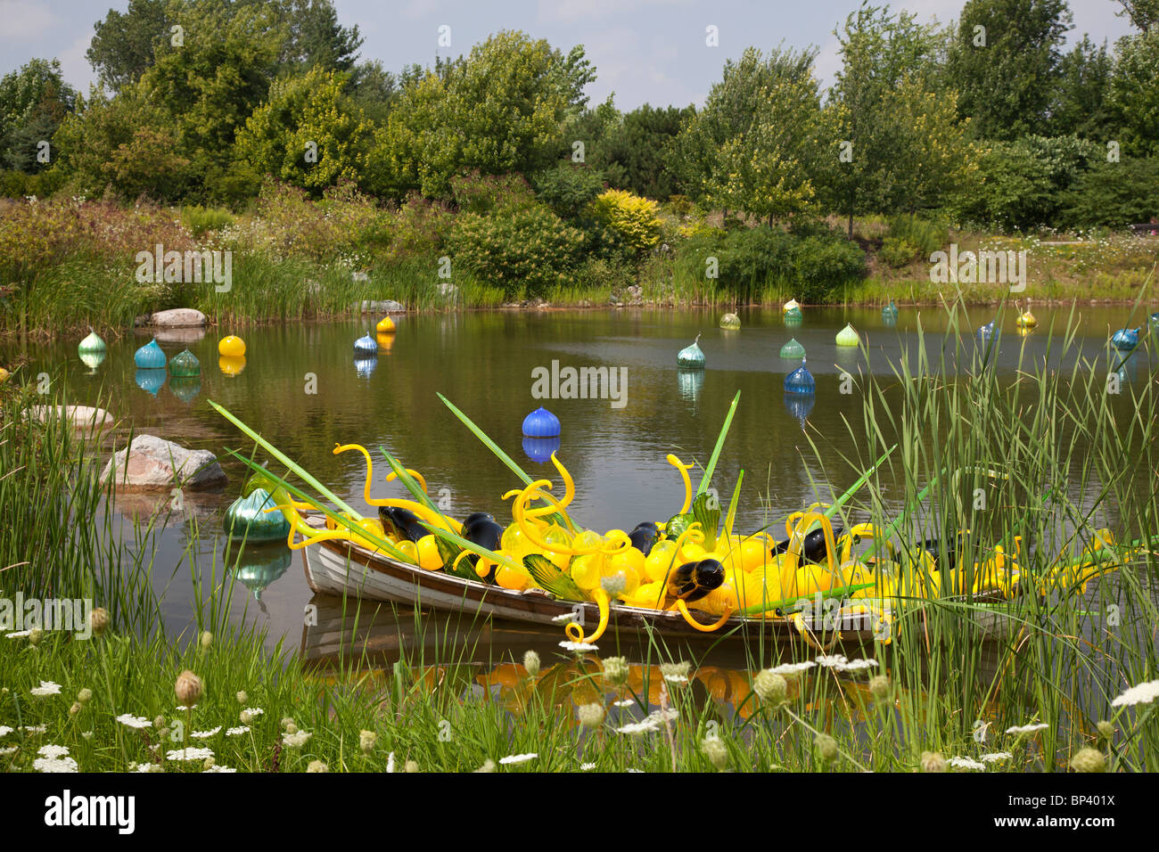 Dale Chihuly's Yellow Boat glass sculpture and floating Walla Wallas on display at the Frederik Meijer Gardens and Sculpture Par Stock Photo