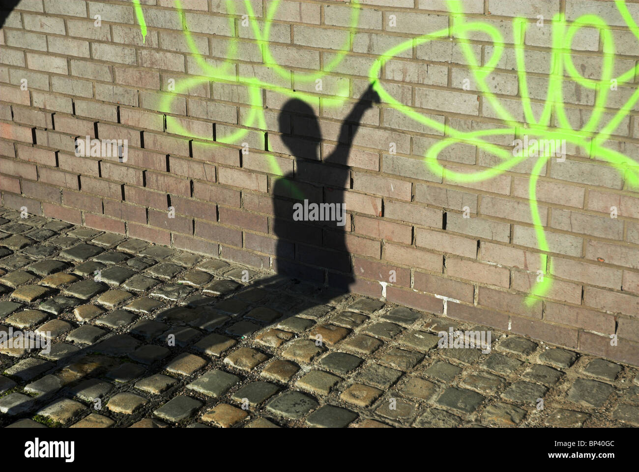 The shadow of a boy when he discovers some graffiti Stock Photo