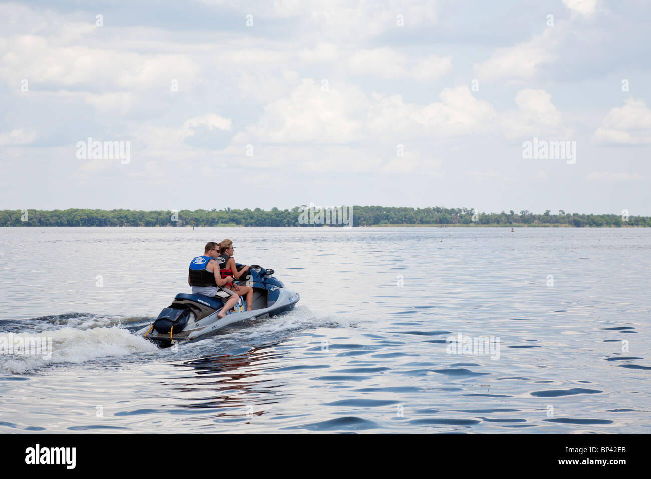 Lake George, FL - May 2010 - Man sits behind woman driving a personal watercraft on Lake George in central Florida Stock Photo