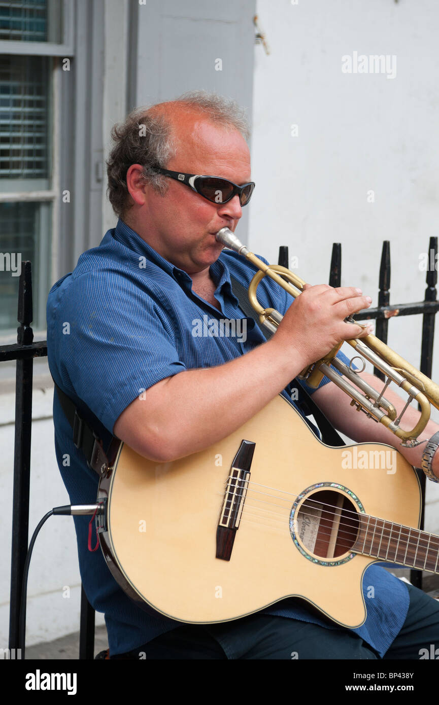 A busker performing in Falmouth, using solar cells and inverter for power Stock Photo