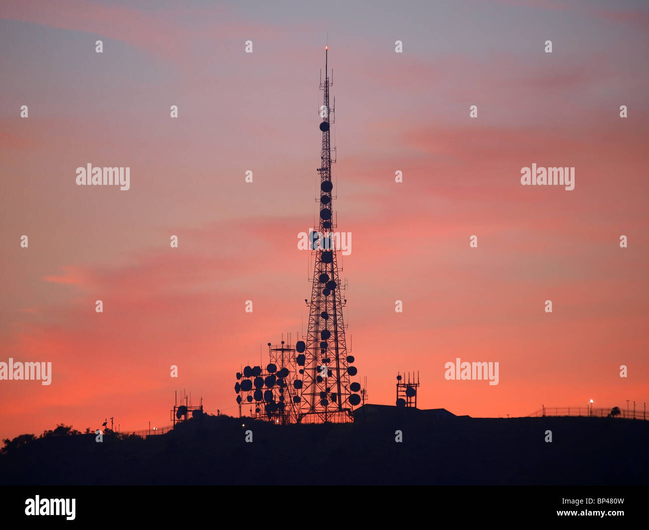 Giant mountain top communication tower with dramatic post sunset sky. Stock Photo