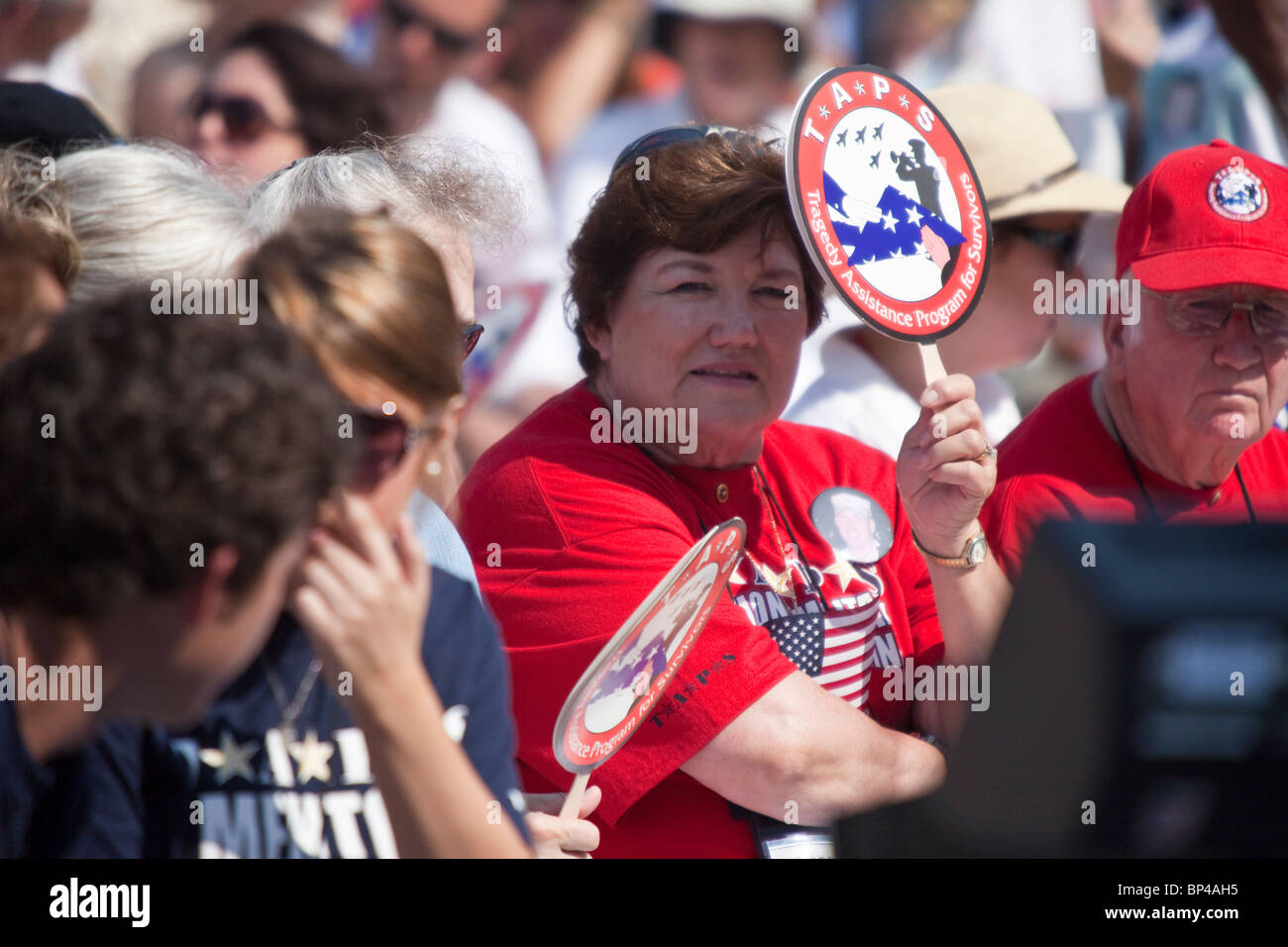 A woman displays a tragedy assistance program for survivors sign at the