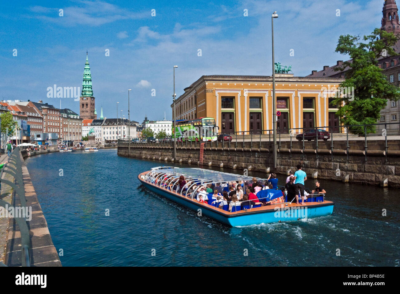 Harbour cruise vessel passes through Frederiksholm Kanal in Copenhagen with Thorvaldsens Museum to the right. Stock Photo