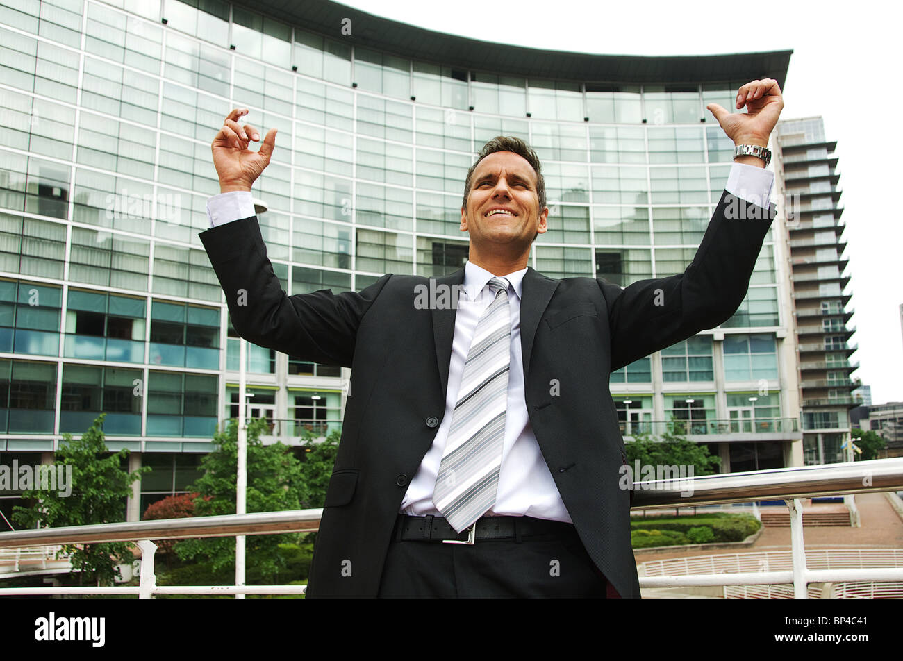 Business man with arms in air suggesting achievement and success Stock Photo