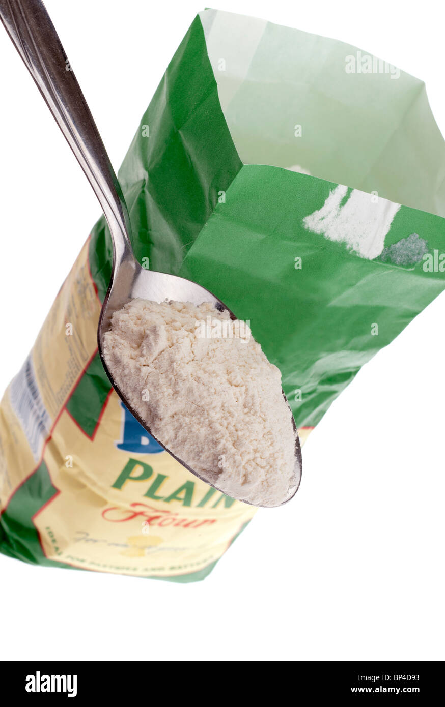 Tablespoonful of plain flour being lifted from a paper bag Stock Photo