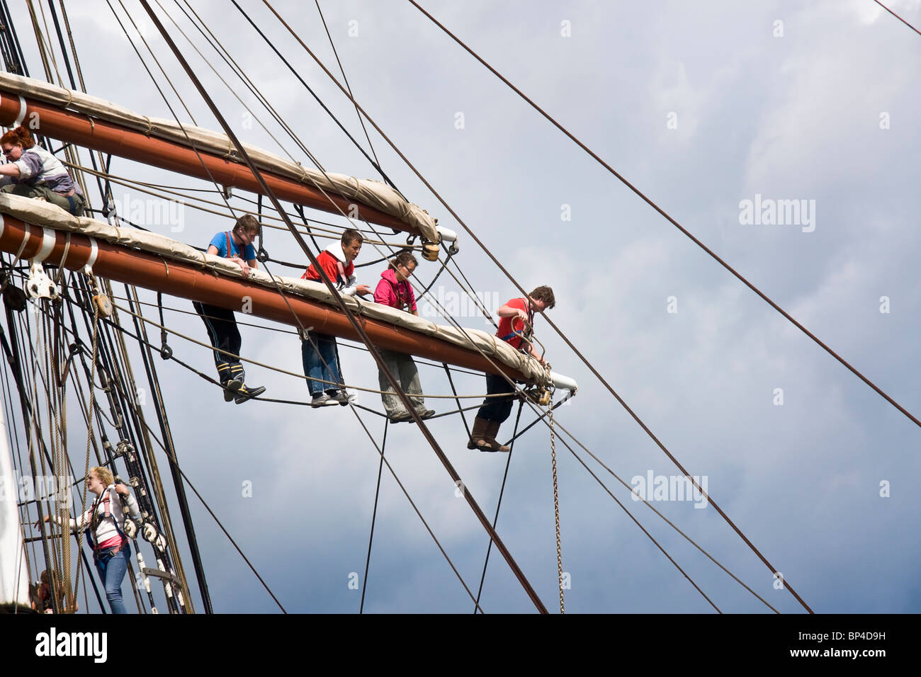Members of the crew of a square rigged sailing ship working on the