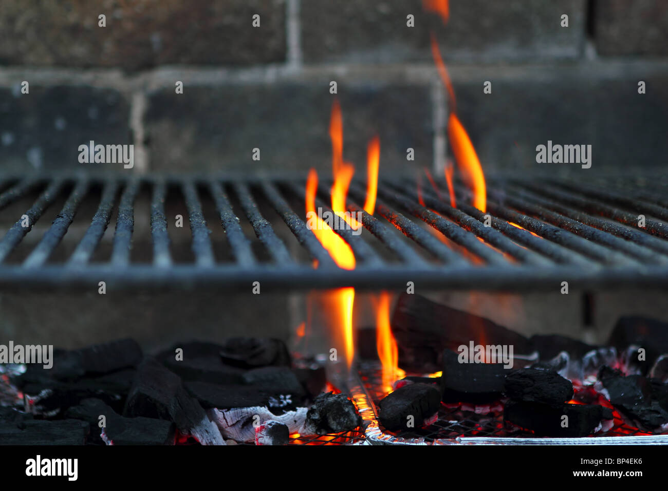 Bar b cue barbecue fire BBQ coal fire iron grill brick wall Stock Photo