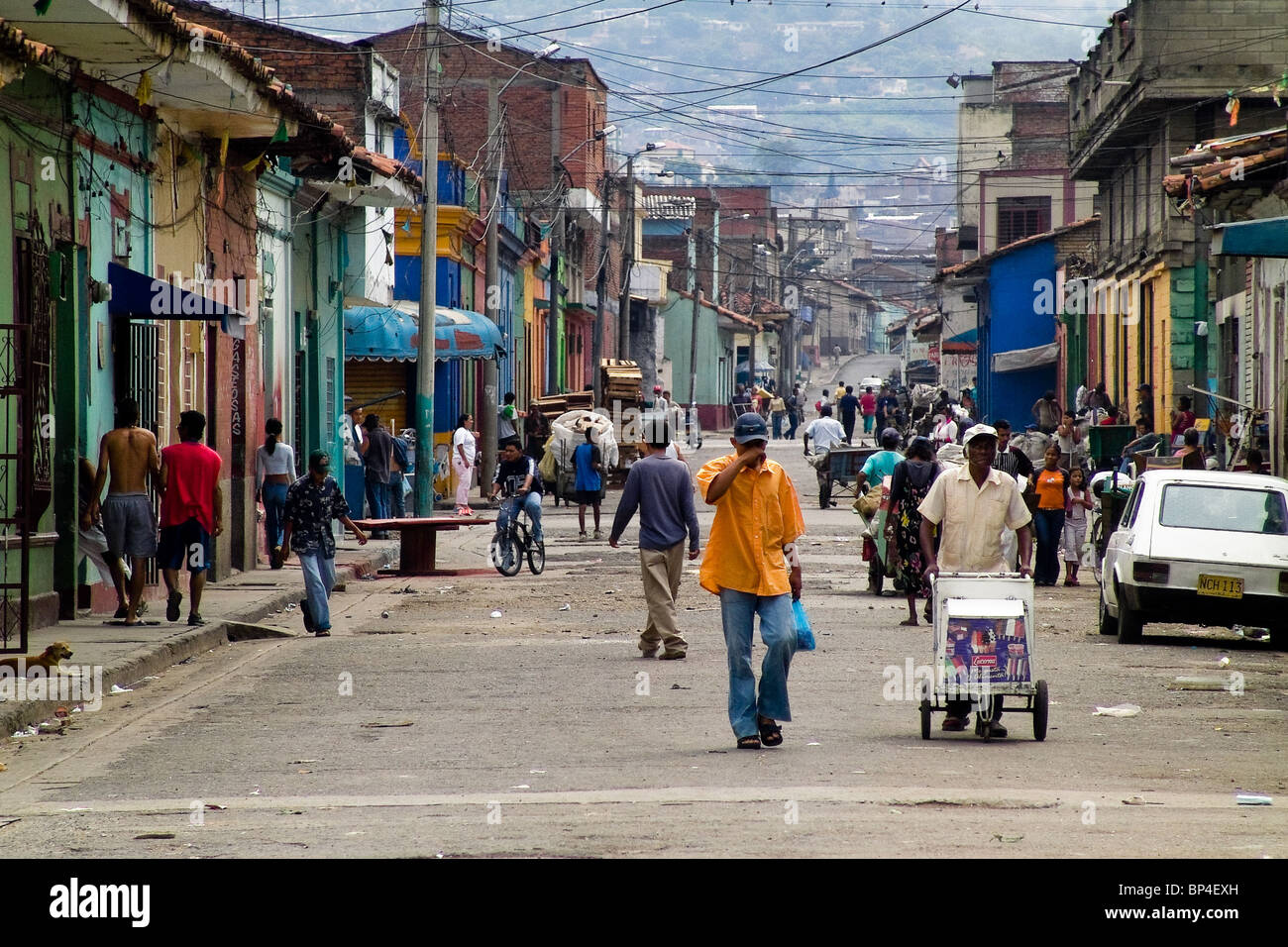 People passing along the main street in the slum of Calvario, Cali, Colombia. Stock Photo