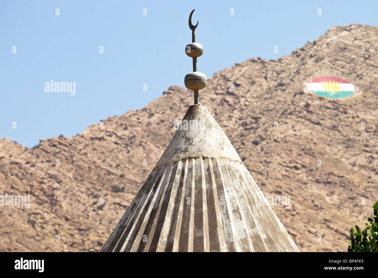 Top of a mosque and the Iraqi Kurdistan flag in Dohuk, Iraq Stock Photo