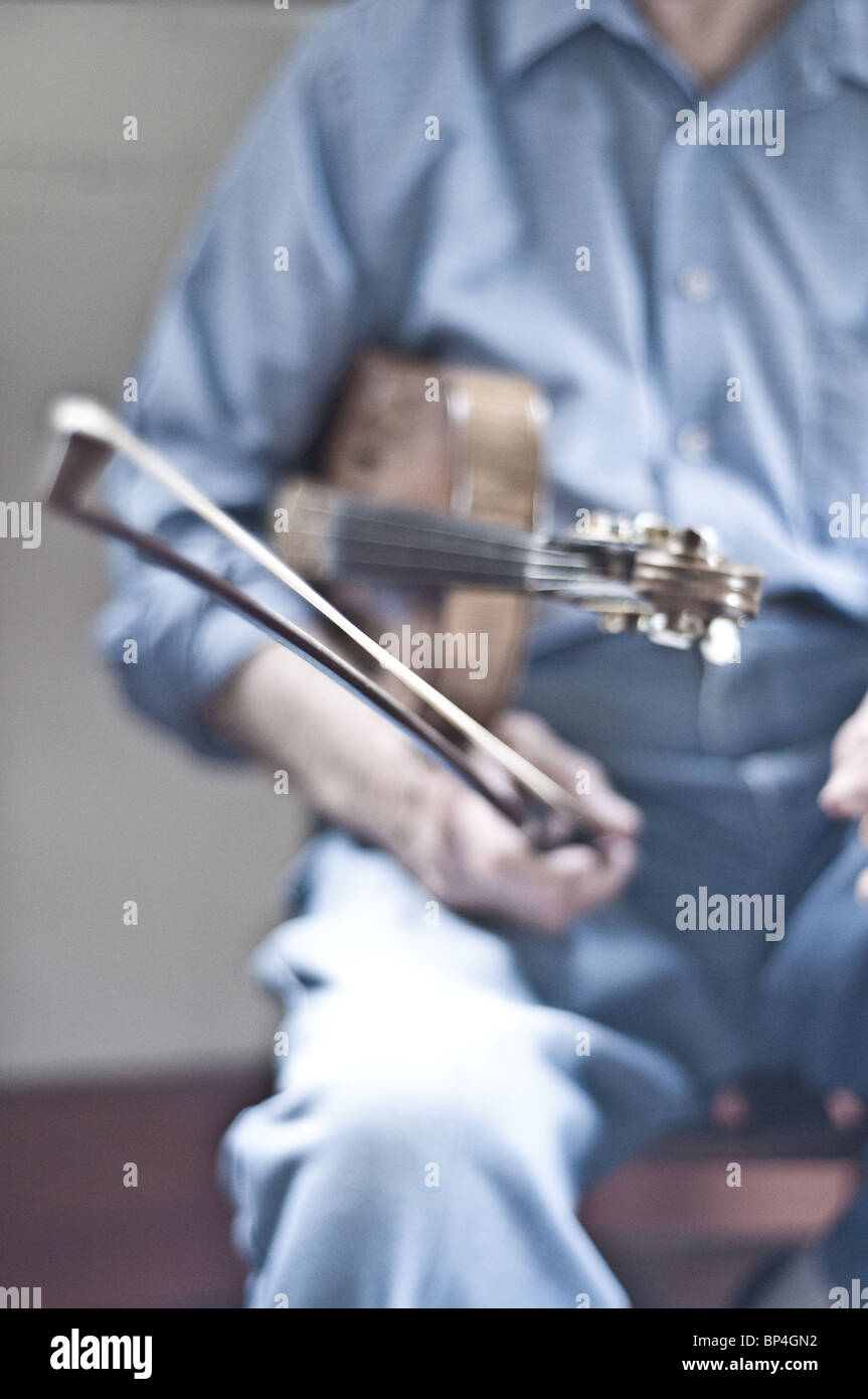 A portrait of an elderly Cajun fiddler holding a fiddle in the old Vermilionville district, of Lafayette, Louisiana, United States. Stock Photo