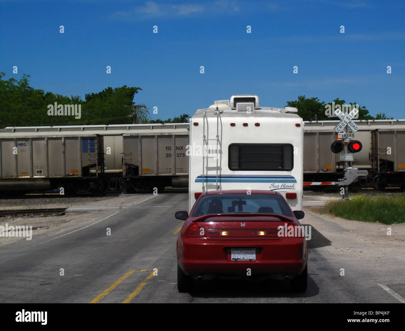 Waiting at railroad crossing Stock Photo
