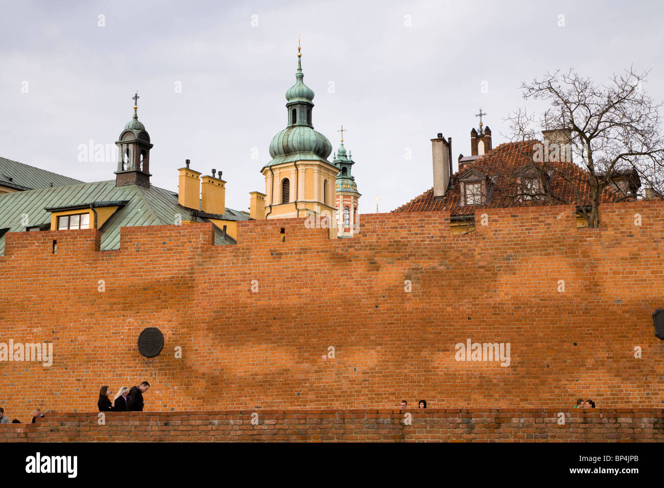 People sitting by Old Town defensive walls, Warsaw Poland. Stock Photo