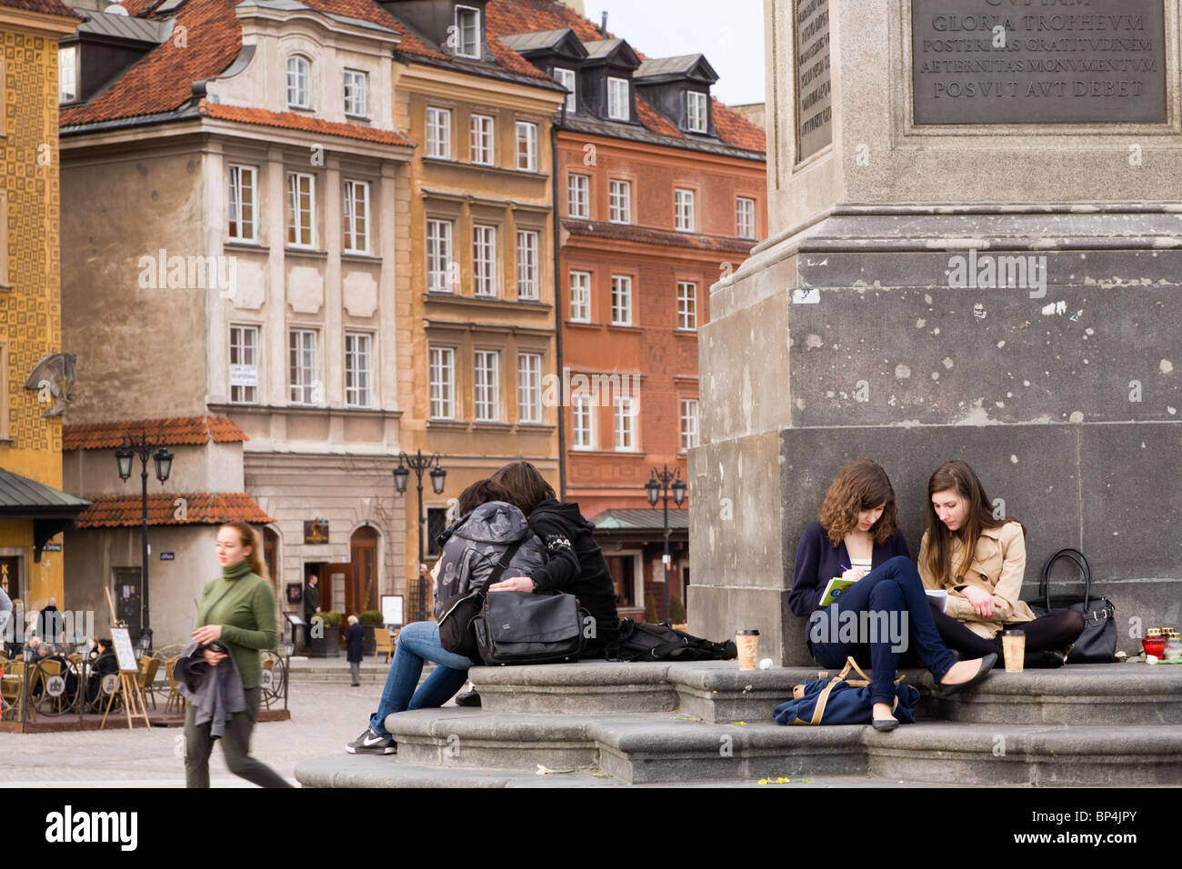 People relaxing by Zygmunt's Column, Warsaw Poland. It is located in the Castle Square, at the entrance to the Old Town. Stock Photo