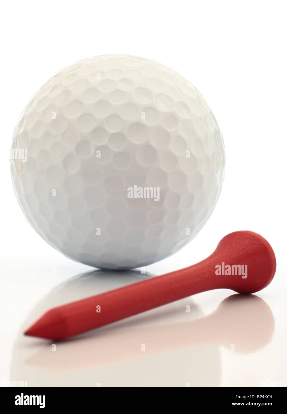 A golf ball and red tee close up reflected. This image is exclusive to Alamy. Stock Photo