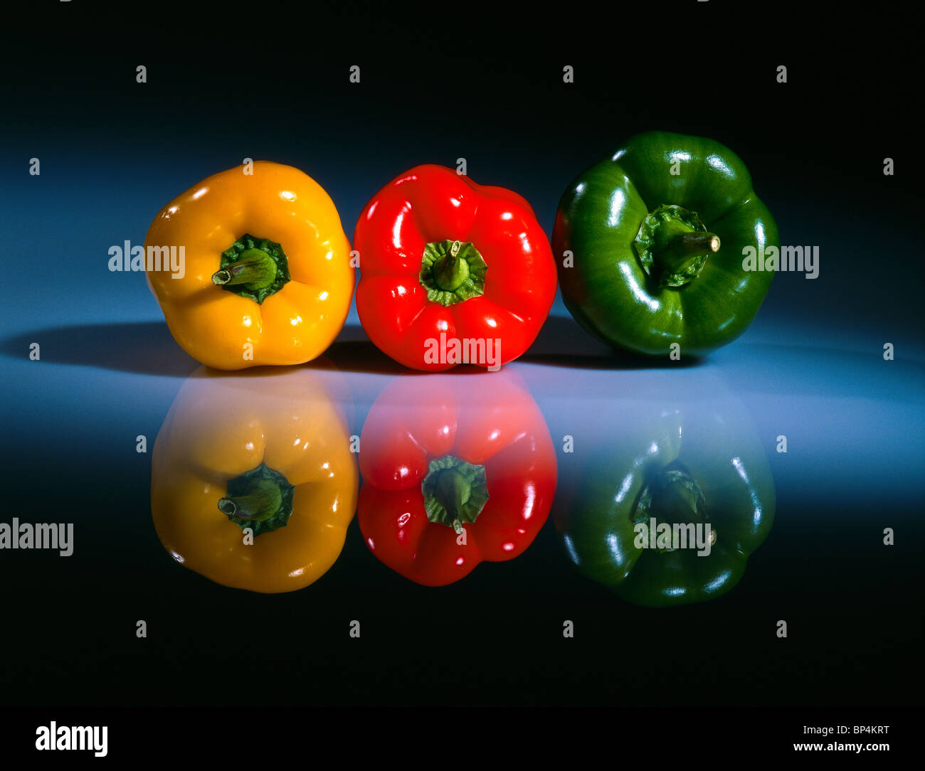 Three fresh colored peppers on a glass table 2 Stock Photo - Alamy