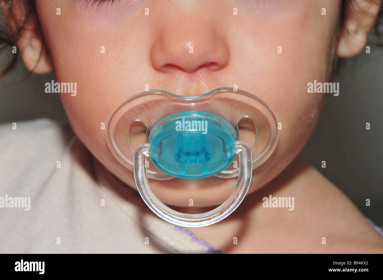 Baby with pacifier in her mouth = Model Release Available Stock Photo