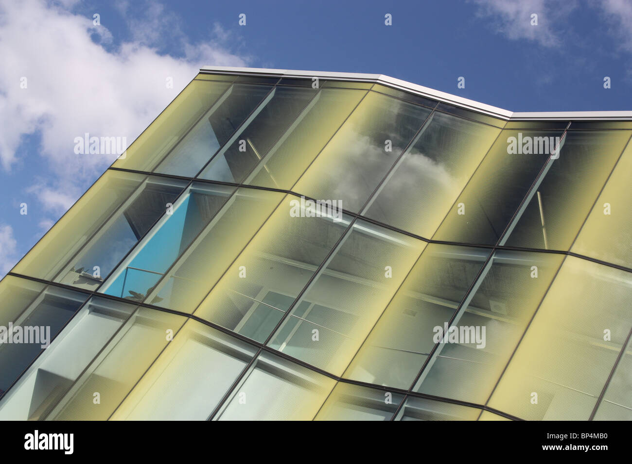 yellow glass building blue sky white cloud Stock Photo