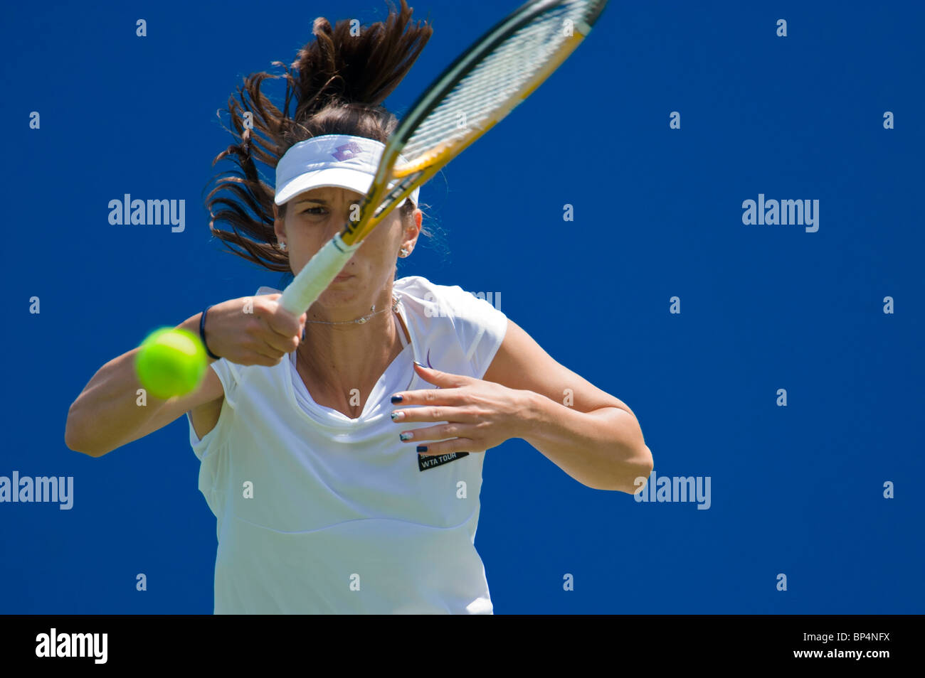 Female tennis player in action hitting forehand. Stock Photo