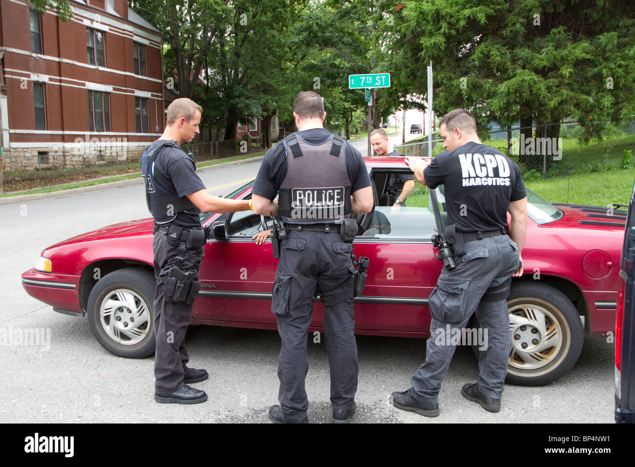 Police officers from tactical team talking to an individual found sleeping in a vehicle in an intersection. Kansas City, MO, PD. Stock Photo