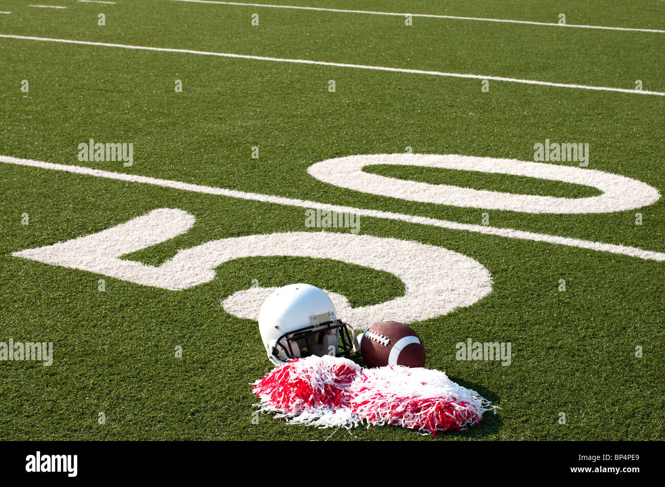 American football, helmet, and pom poms on field Stock Photo - Alamy
