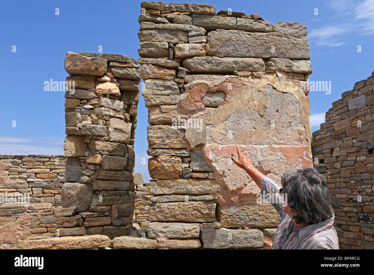 Basilika, the tour guide, pointing at antique plaster on a wall, archaeological excavation, island of Delos, Cyclades, Greece Stock Photo