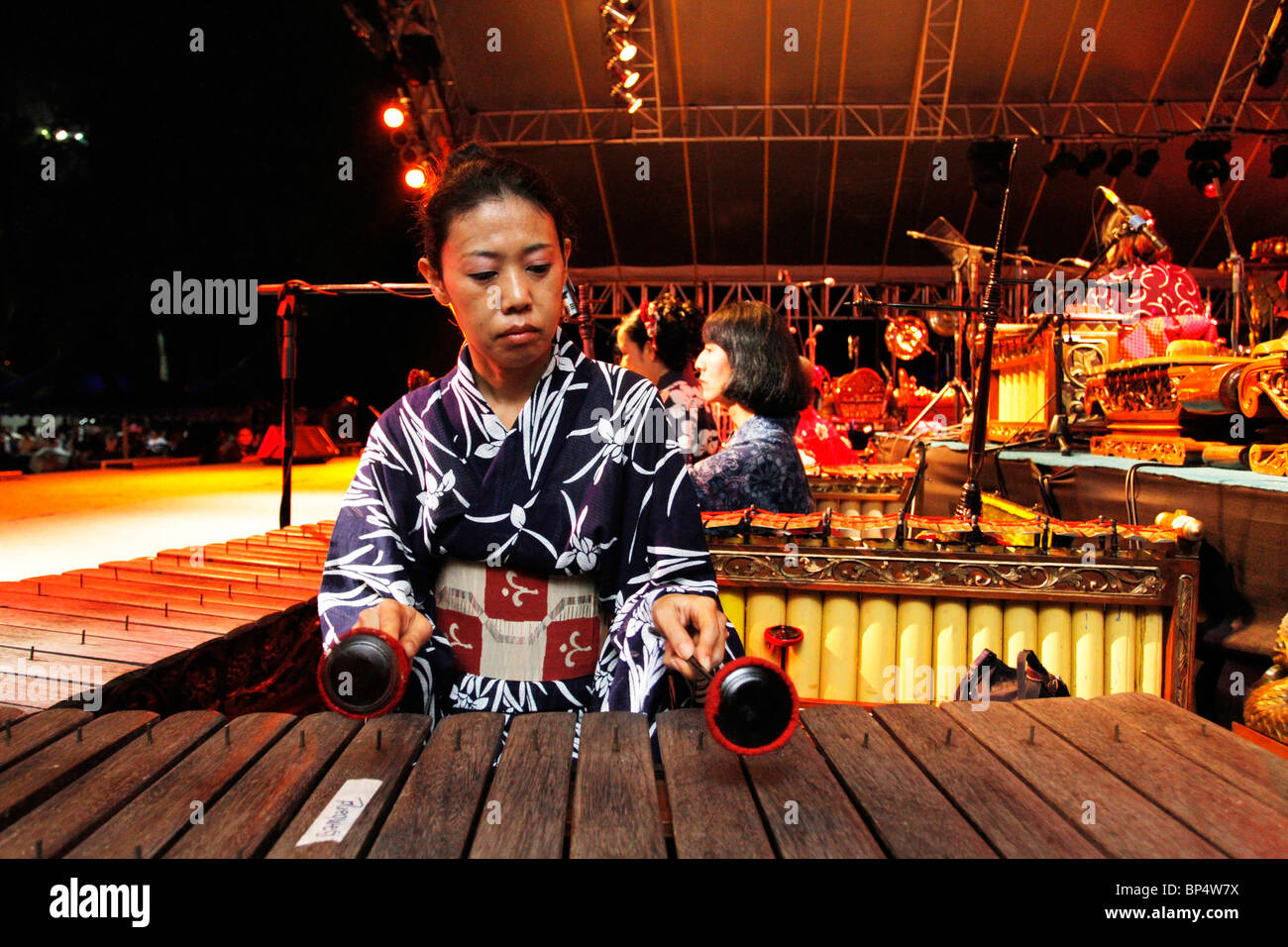 A Japanese wearing Kimono playing the xylophone on stage during the