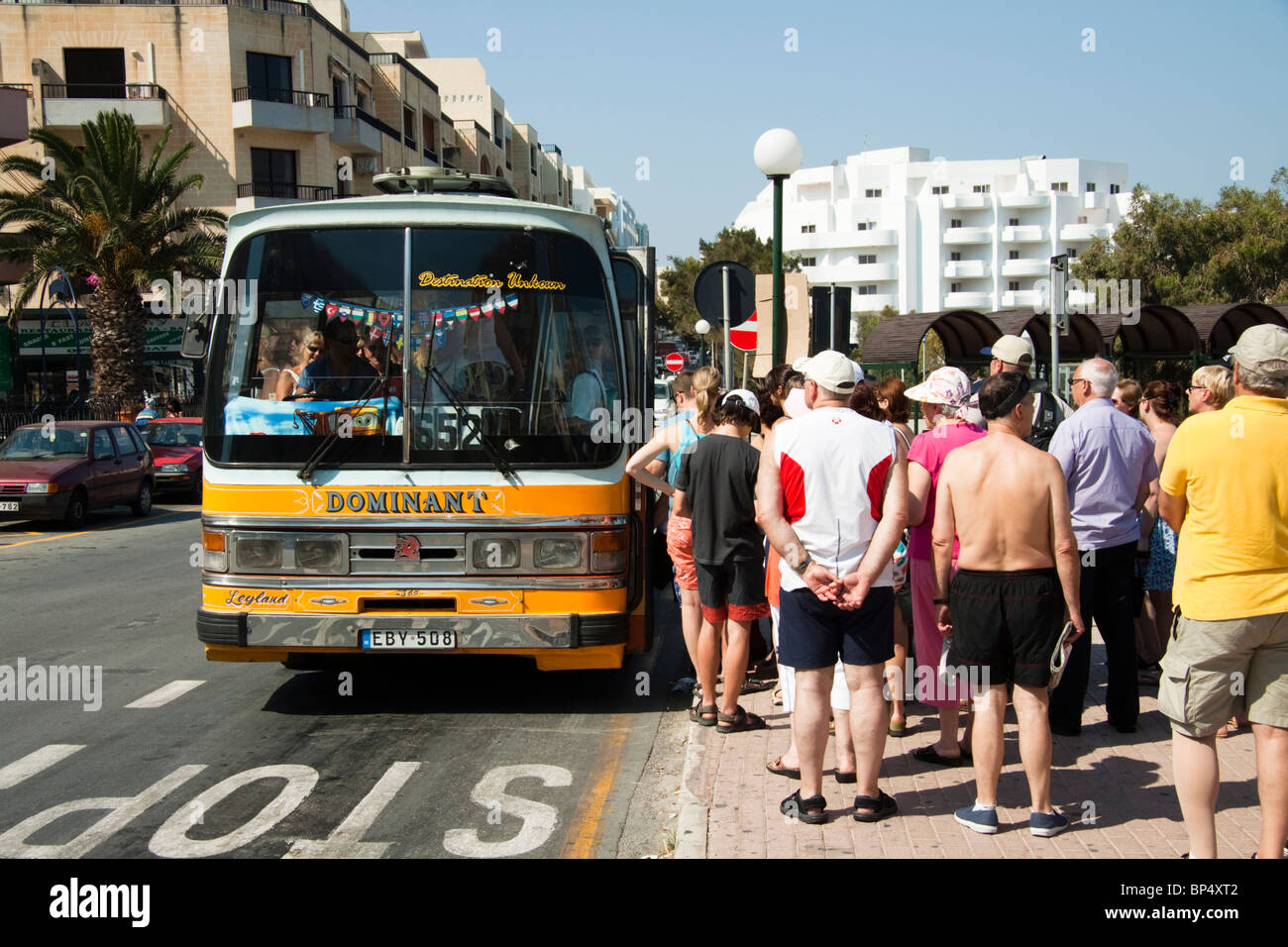 Tourists queuing to get on a bus, Bugibba, Malta Stock Photo