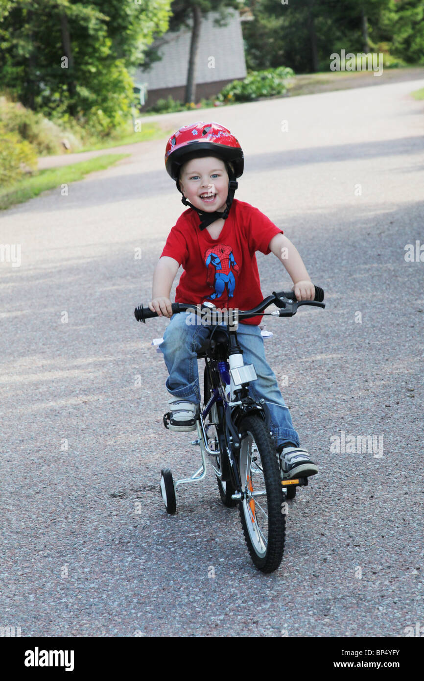 Little boy toddler riding his first bicycle with stabilisers MODEL RELEASED Stock Photo