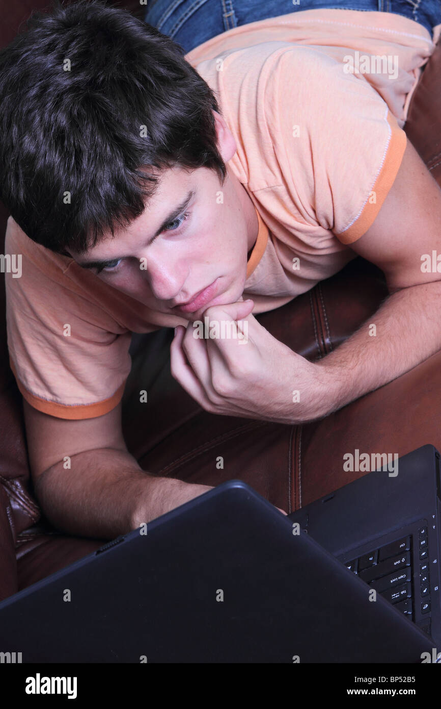 Young man with laptop surfing Inernet Stock Photo