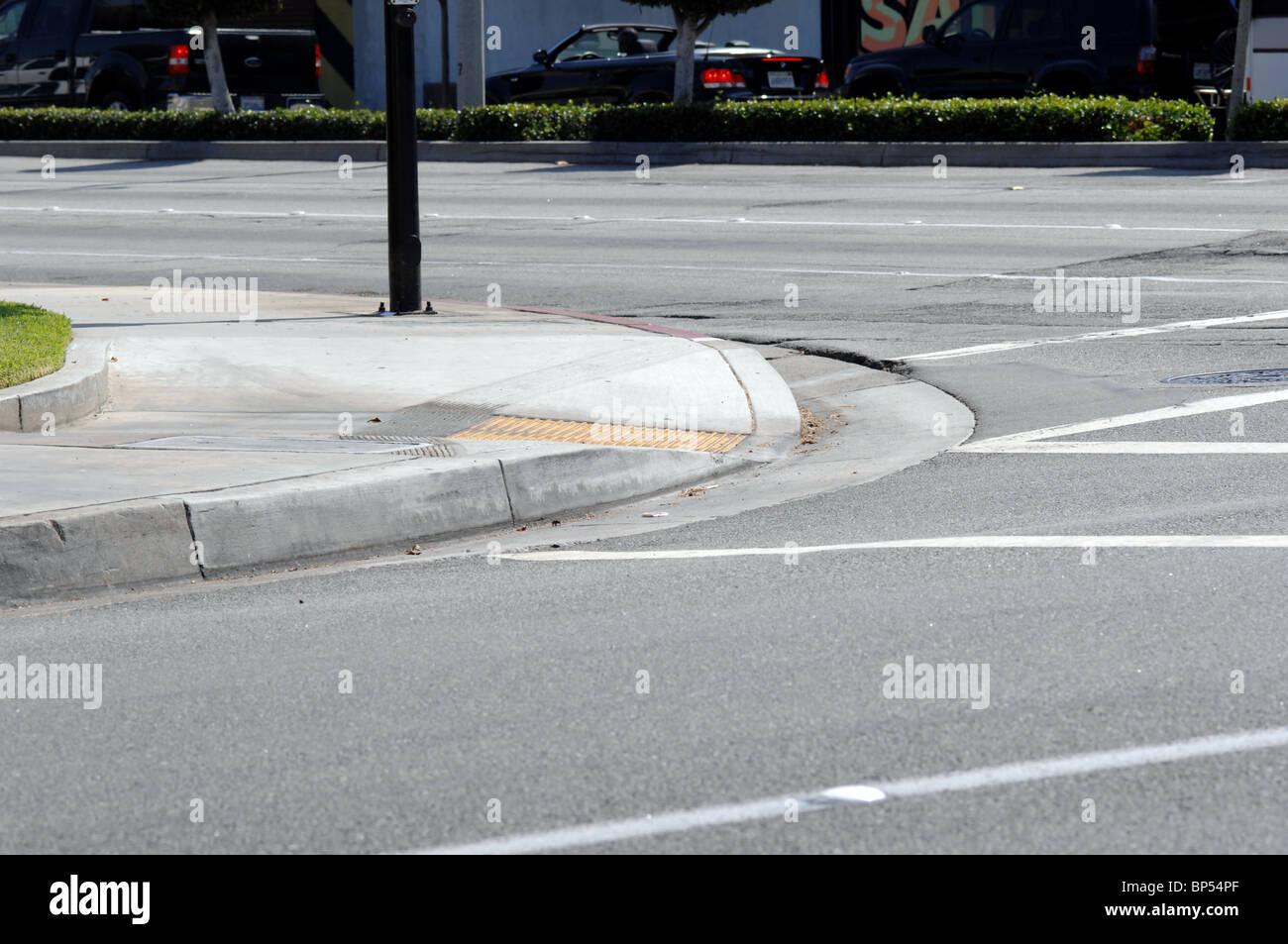 Curb with ramp for handicapped access to the street. Stock Photo