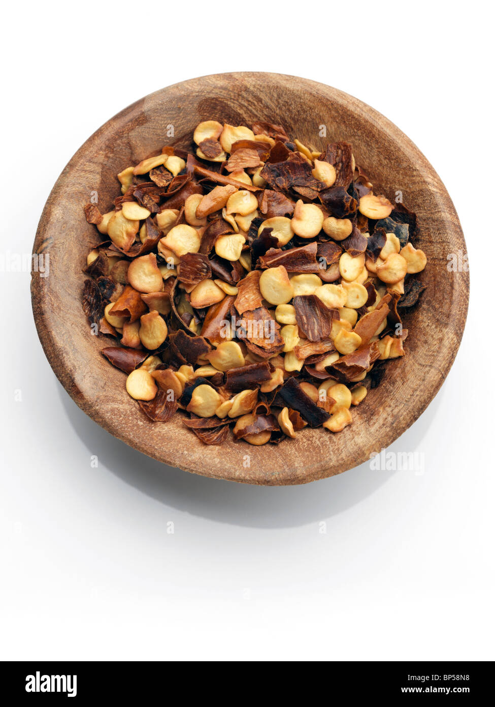 A wooden bowl of crushed chillies on a white background Stock Photo