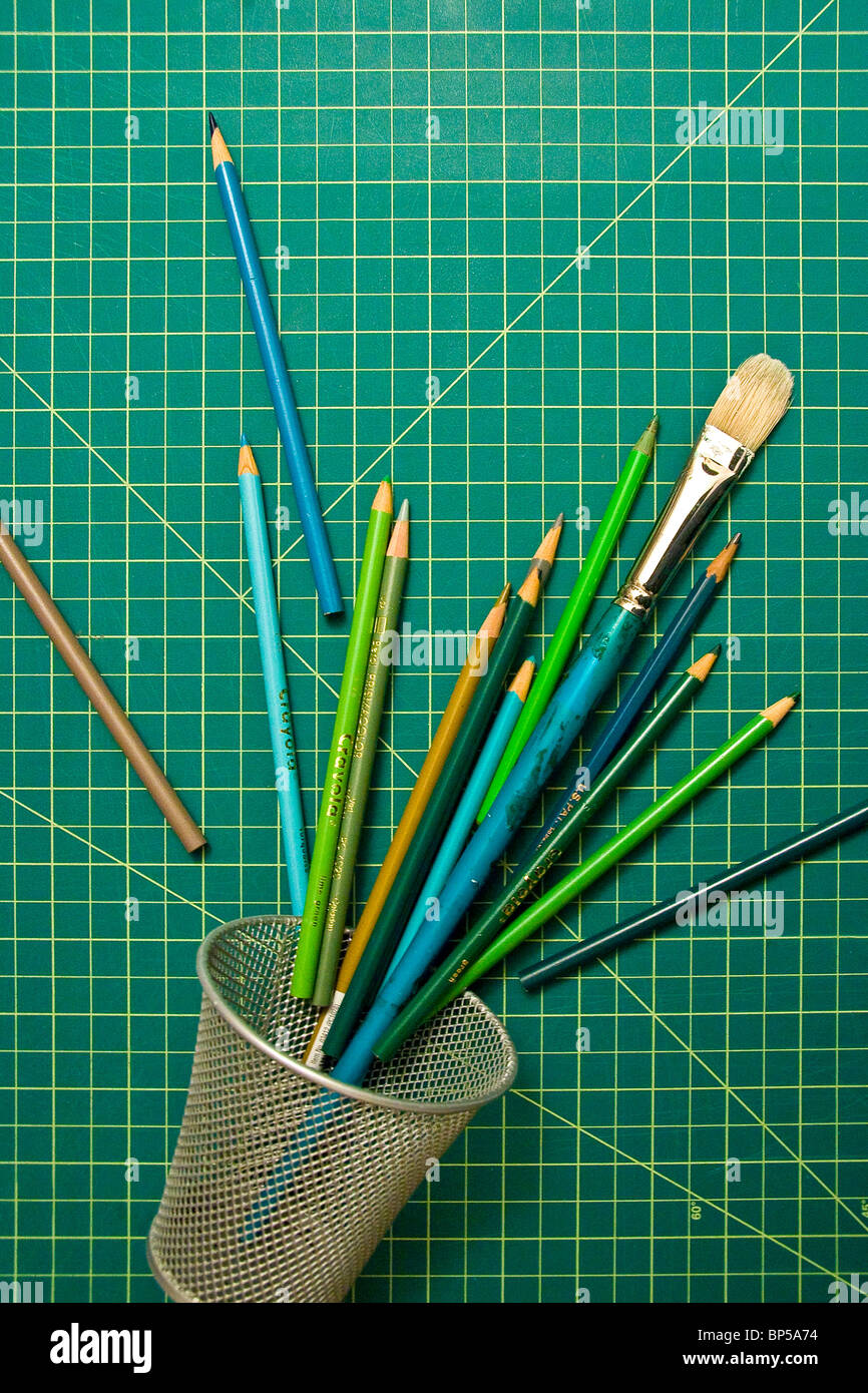 Drawing pencils and paint brush on a cutting board Stock Photo