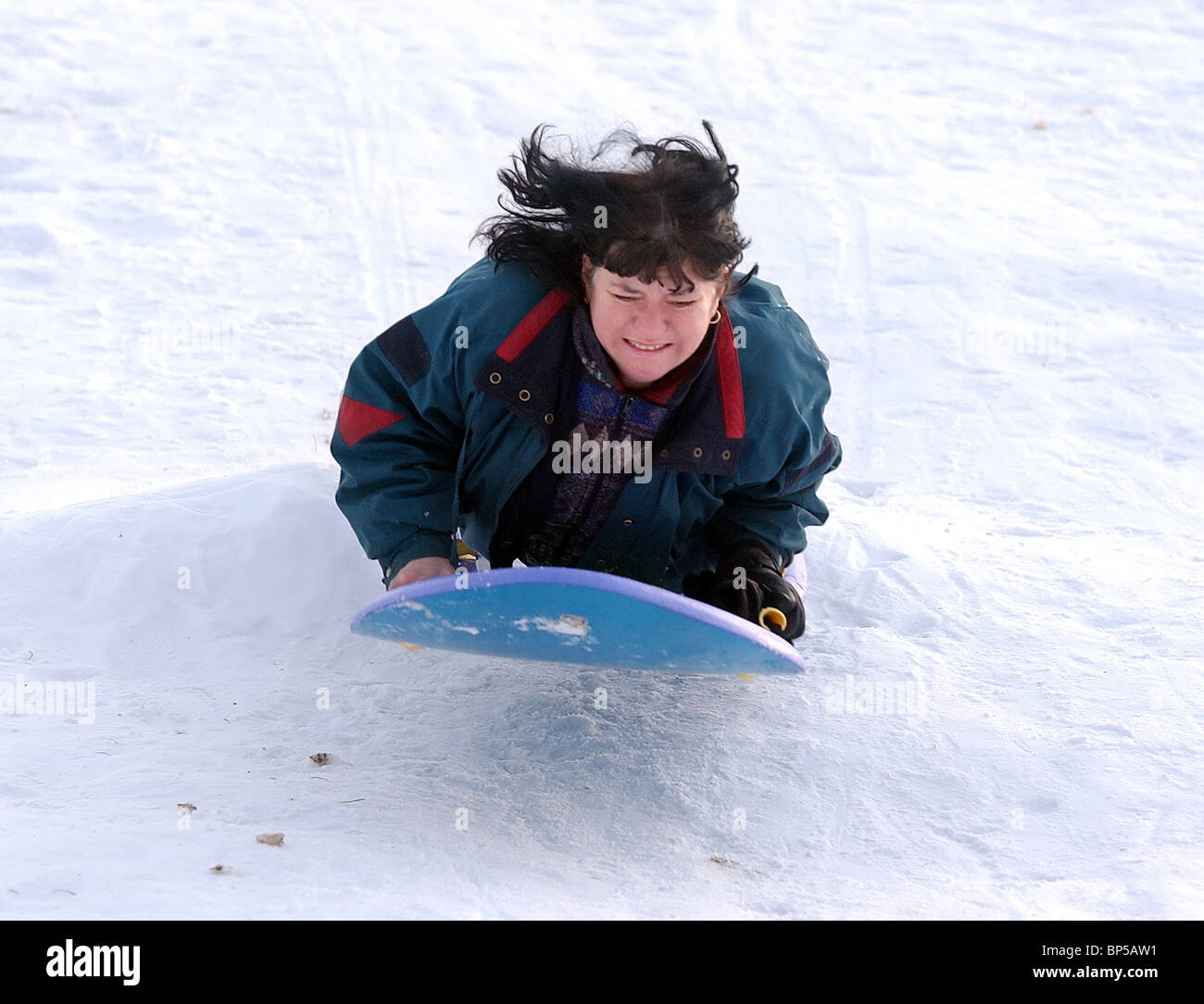 A child sledding jumping off snow ramp in CT USA during winter Stock Photo