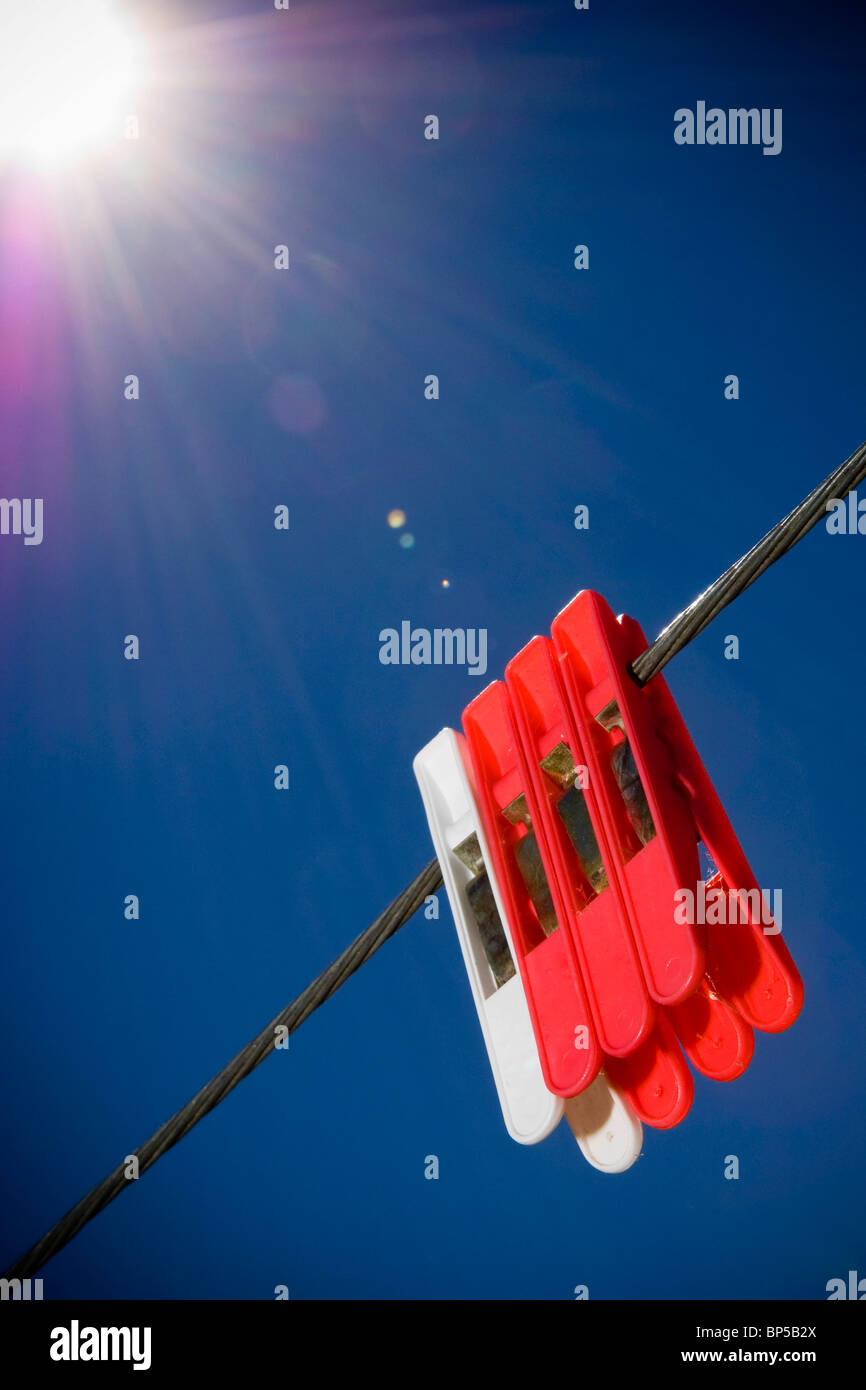 Generic pegs on a washing line in clear blue sky Stock Photo