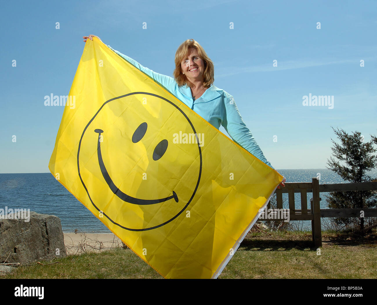 Woman who runs a happiness club in Connecticut USA with smiley face flag Stock Photo
