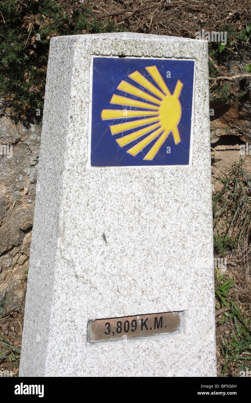 Stone and ceramic waymarker on the Santiago way at Cap Finisterre / Cabo Fisterra, Galicia, with KM and scallop shell sign. Stock Photo