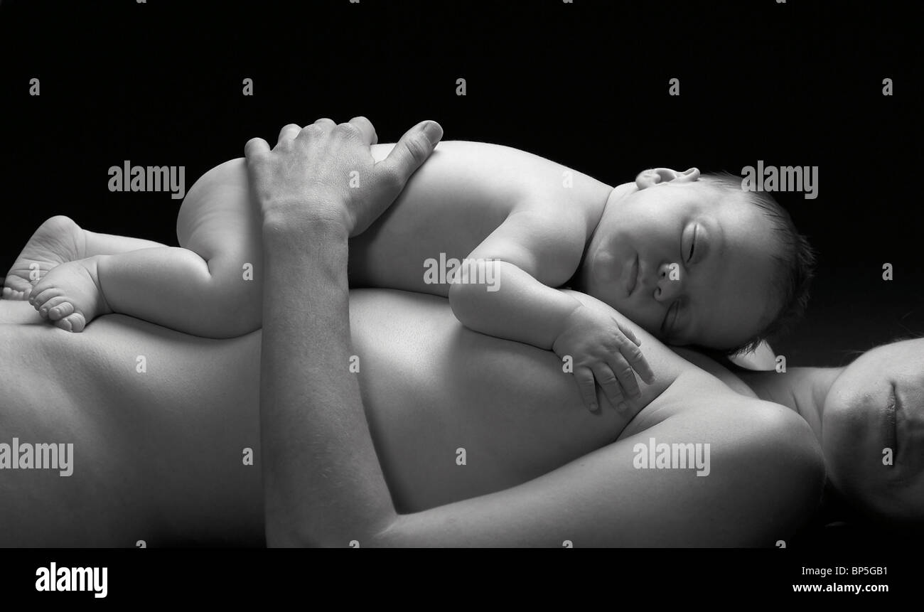 Newborn baby sleeping on mothers stomach. Stock Photo