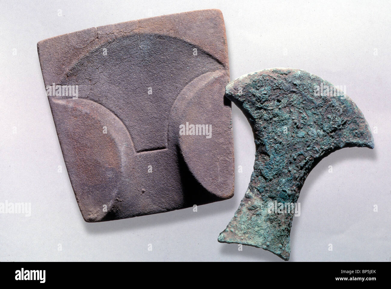 EGYPTIAN STYLE AX WITH THE STONE MOULD IN WHICH IT WAS CAST. THE REAR PORTION OF THIS TYPE OF AXE IS INSERTED INTO THE WOODEN Stock Photo