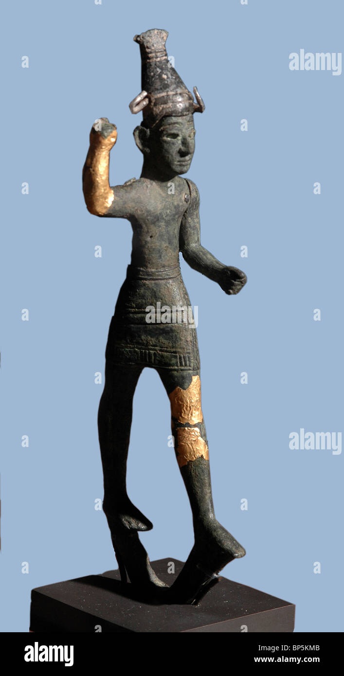 Figurine of the Storm God Baal. The figurine is covered in gold & silver. The right arm is risen upwards as if brandishing a Stock Photo