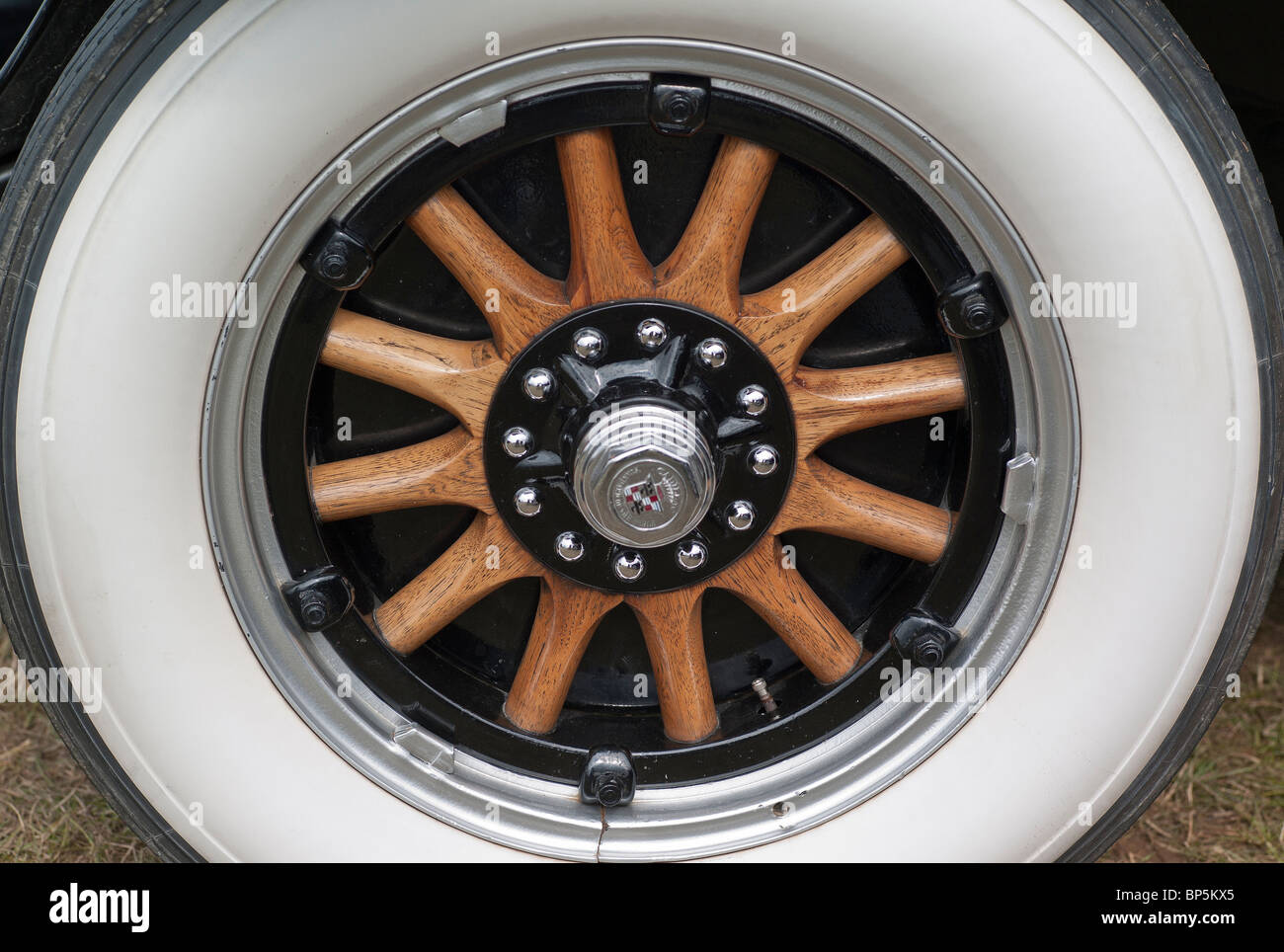 Wooden spoked automobile wheel with whitewall tyres in UK Stock Photo