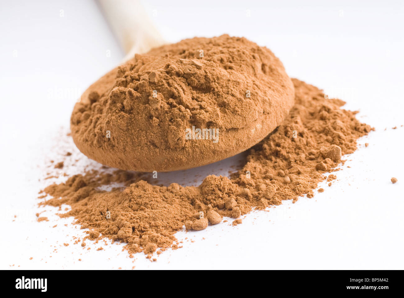 ground carob in a wooden spoon,Ceratonia siliqua powder Stock Photo