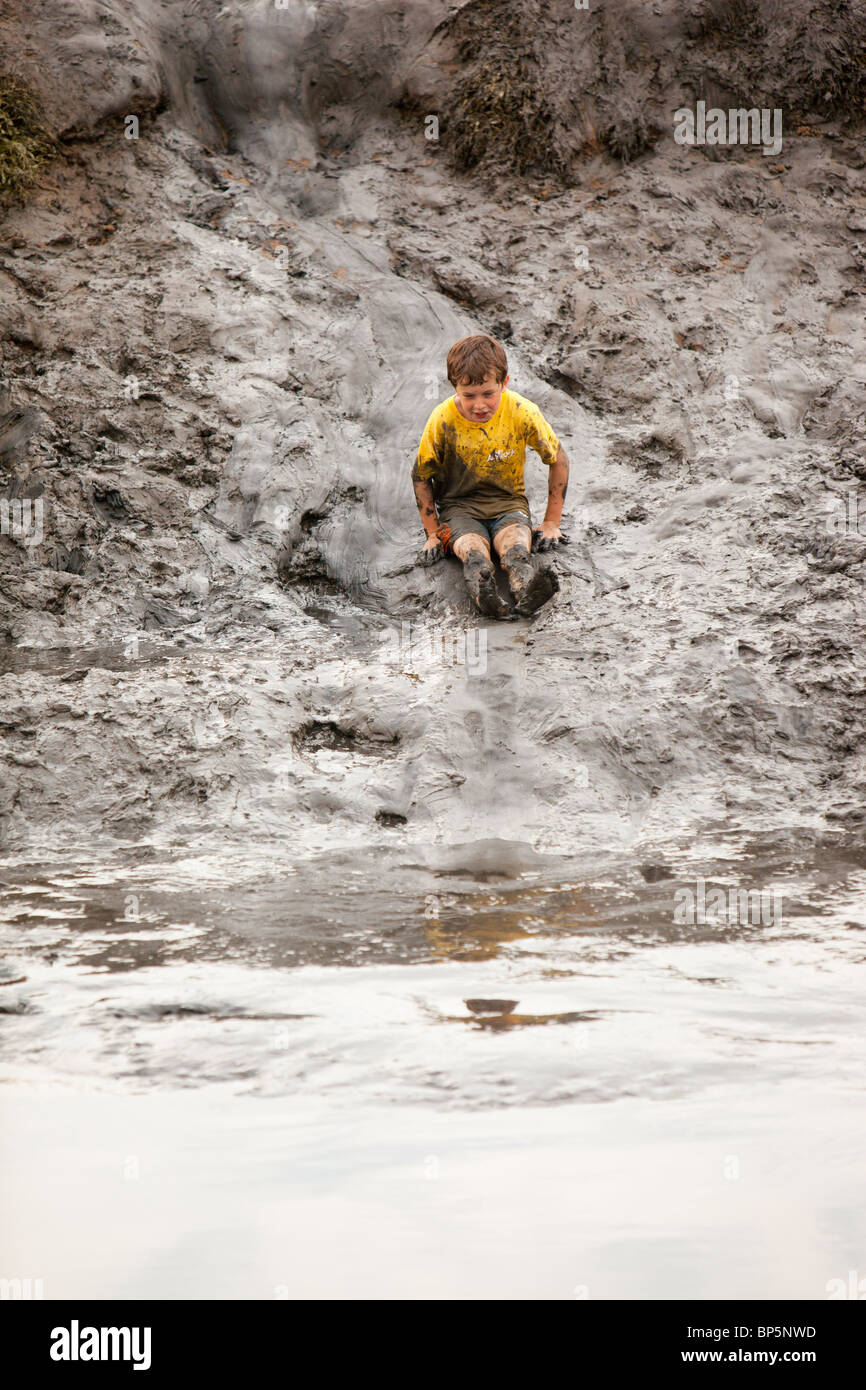Children playing in a muddy creek at Blakeney, North Norfolk, UK. Stock Photo