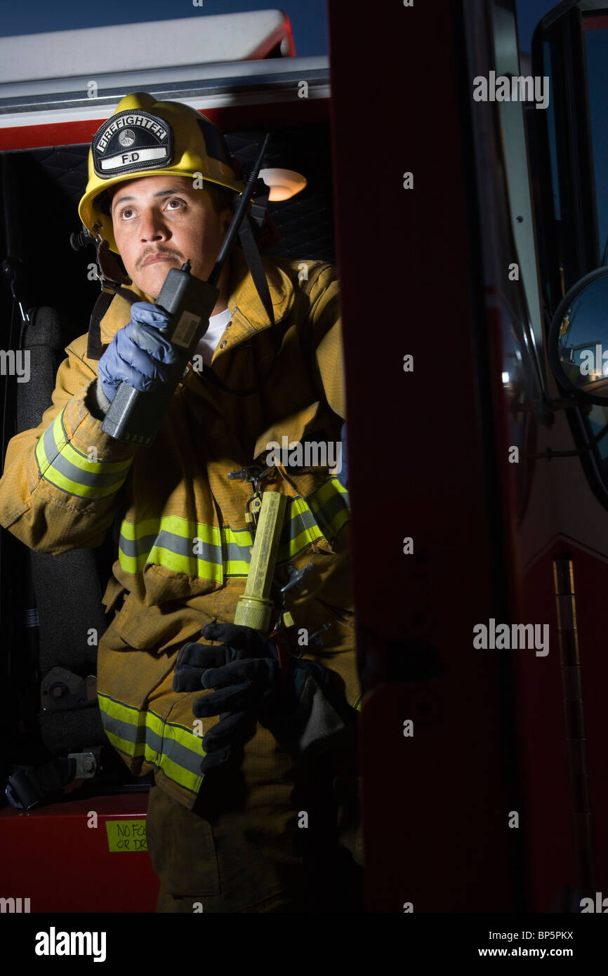 Firefighter using walkie talkie by fire engine Stock Photo - Alamy