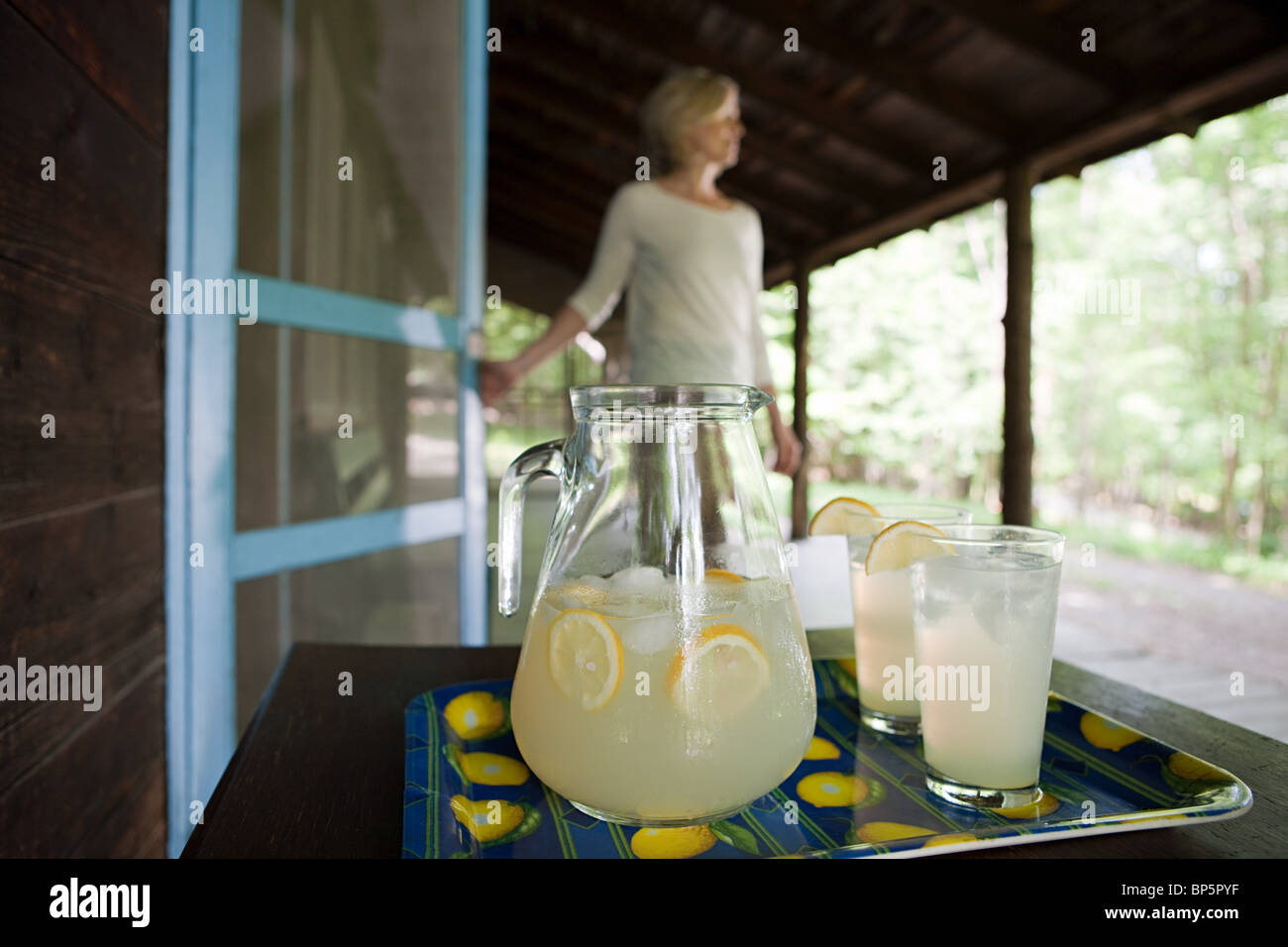 Tray of lemonade, woman in background Stock Photo