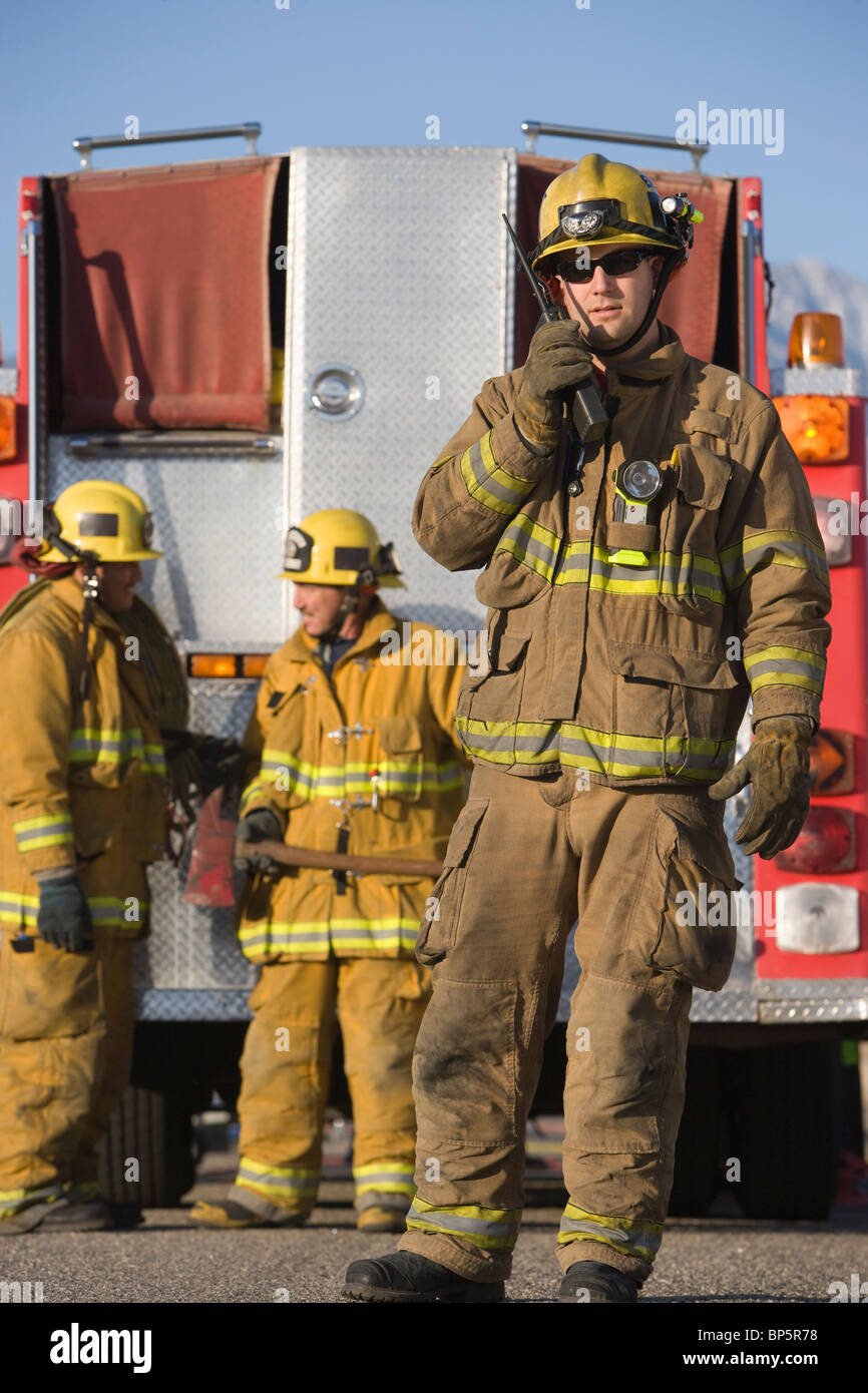  Firefighter  using walkie talkie by fire  engine  Stock Photo 