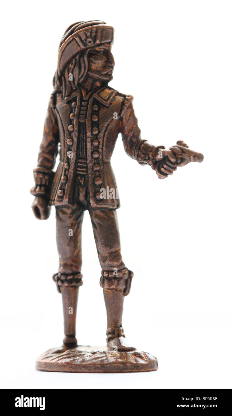 Close-up photograph of a one-inch rusty metal toy pirate wearing a 1700s uniform isolated on a white background. Stock Photo