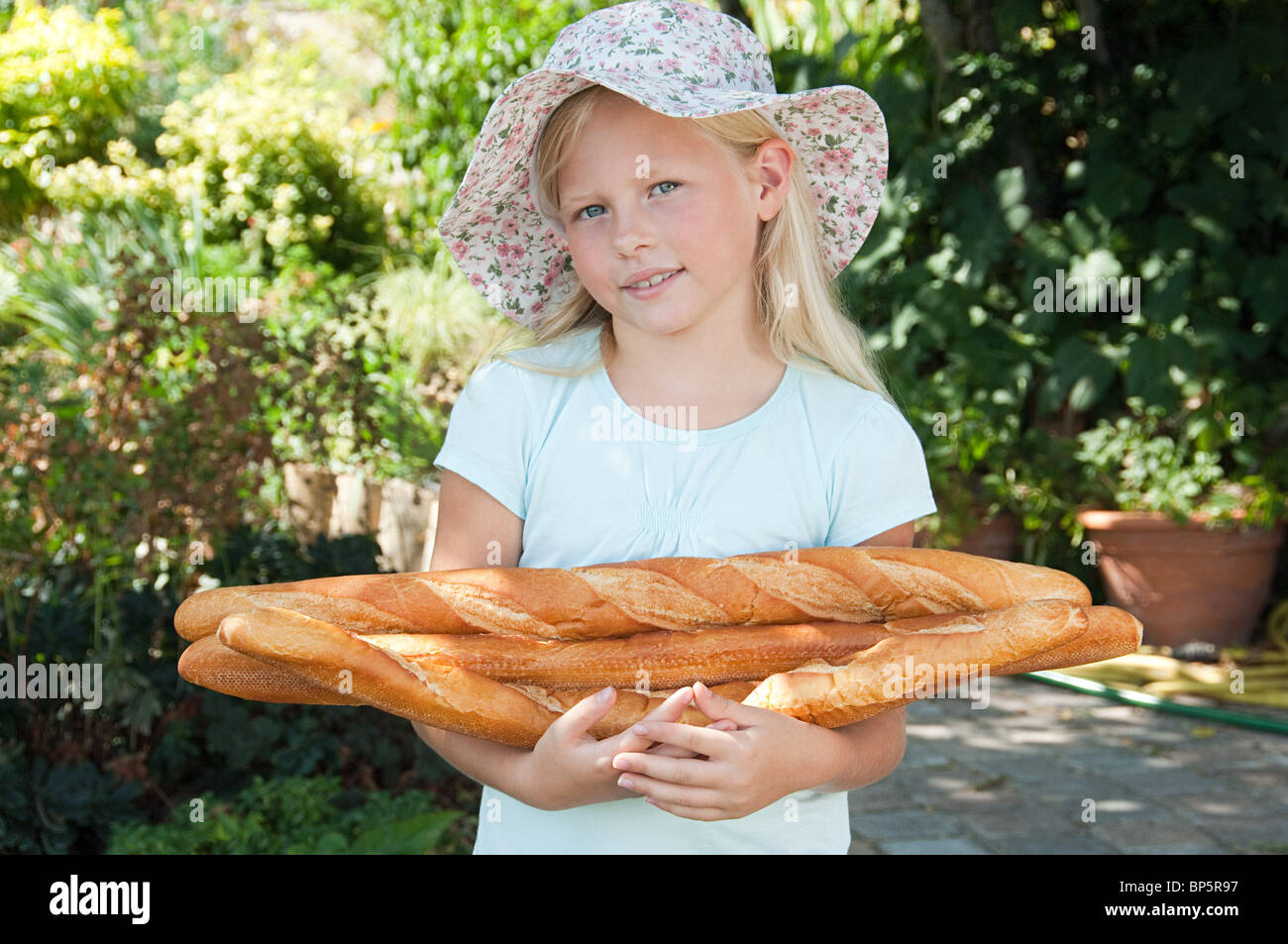 Girl in sunhat holding baguettes Stock Photo Alamy