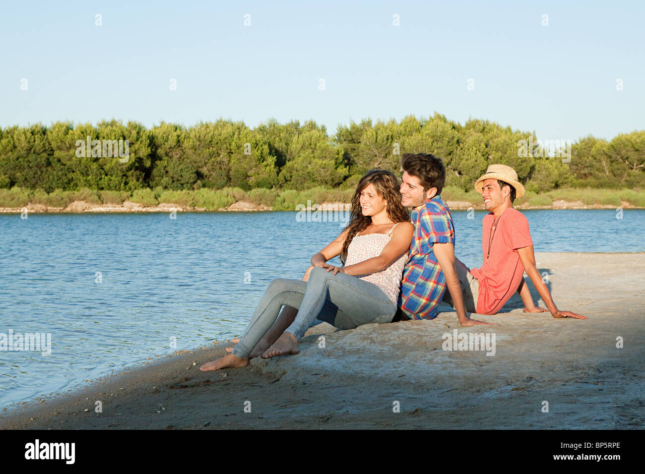 https://c8.alamy.com/comp/BP5RPE/young-friends-sitting-on-sand-BP5RPE.jpg