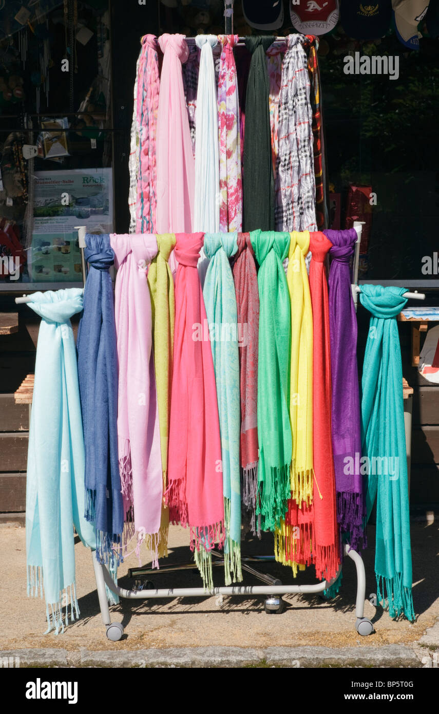 Colourful scarves for sale hanging on a display stand outside a shop Stock Photo