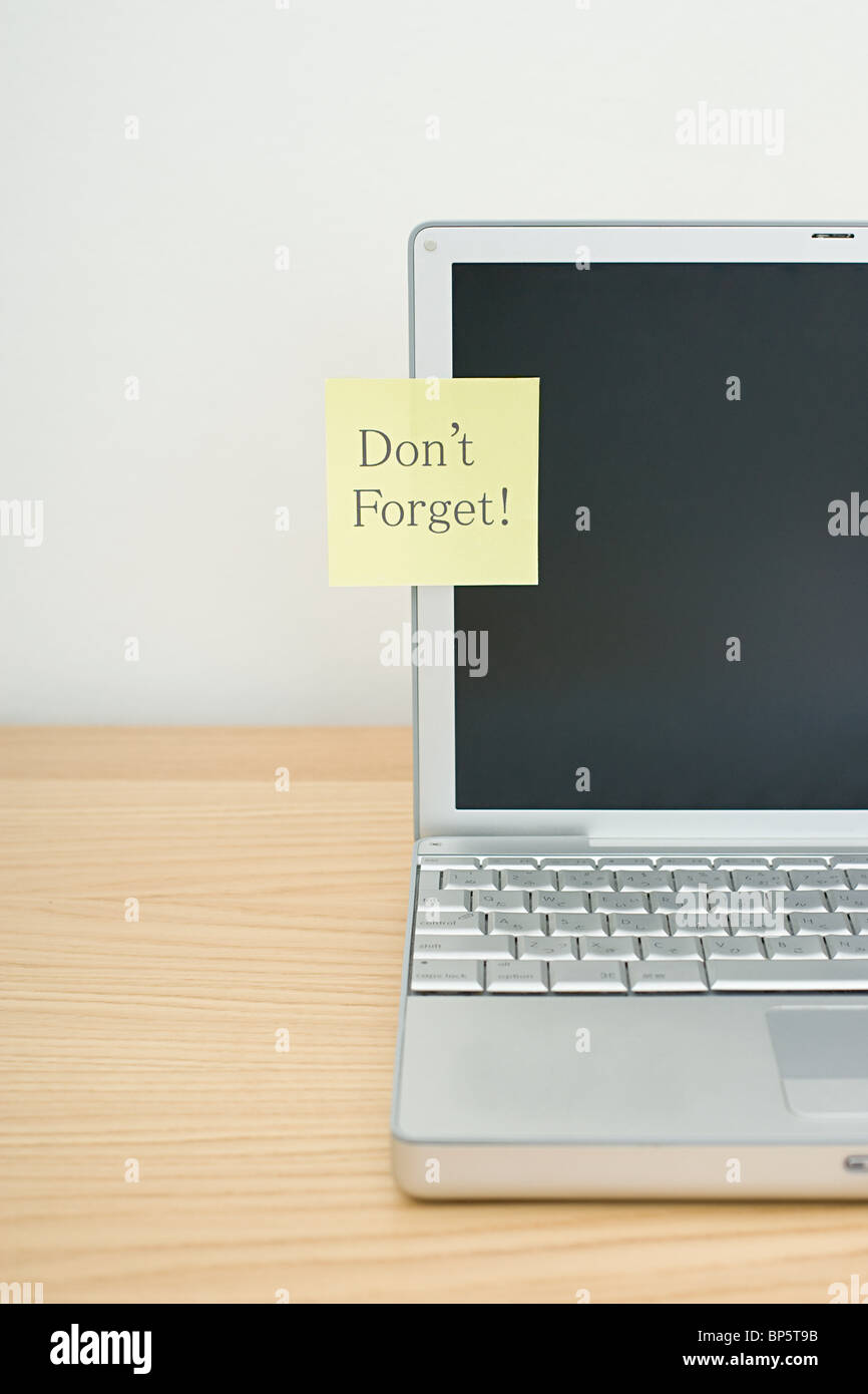 Don't forget written on adhesive note on laptop Stock Photo